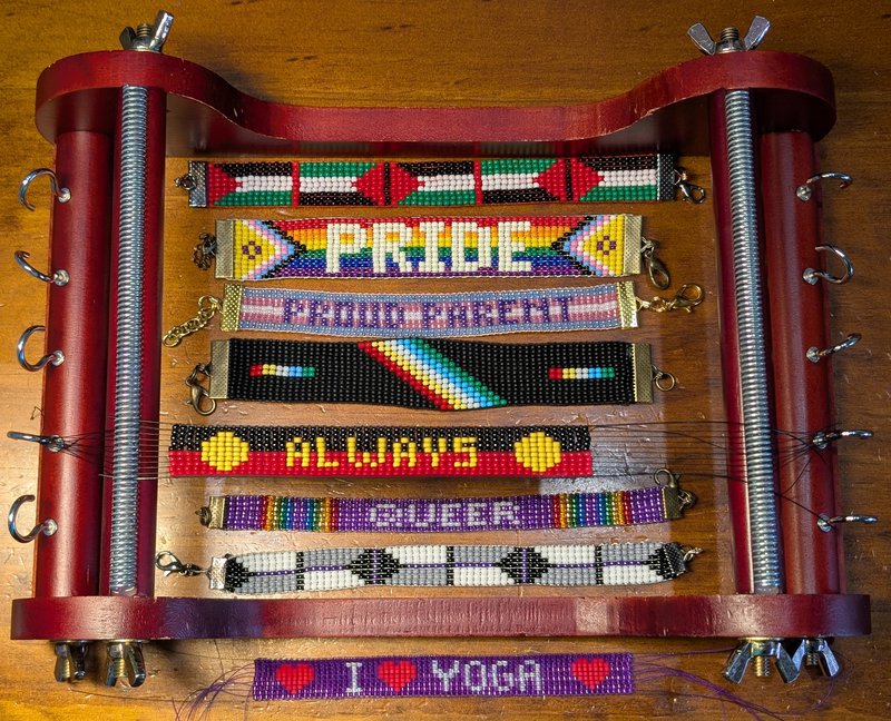 a beading loom with various beaded bracelets